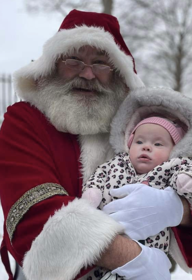Picture of Dave Clayton as Santa holding a small baby