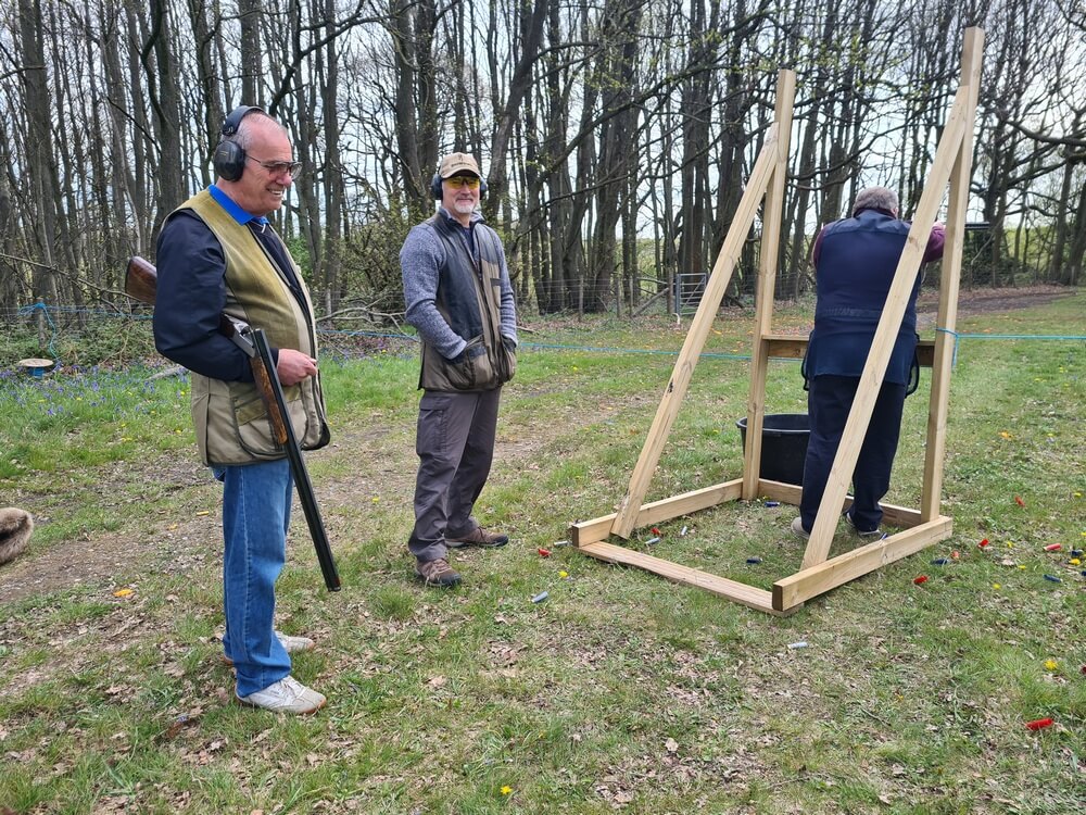 Picture of some of the shooters watching on and enjoying the day. One shooter is in the stand whilst two watch on.
from left to right;  Rob Styles,  Mick Daly and Nick Jenkins shooting.

