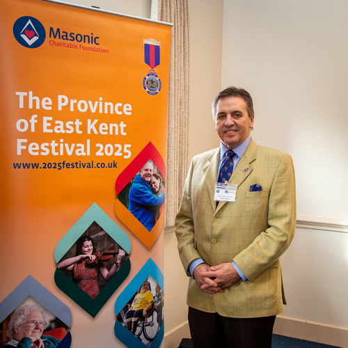 Picture of Richard Dixy, a visiting volunteer standing next to the MCF banner