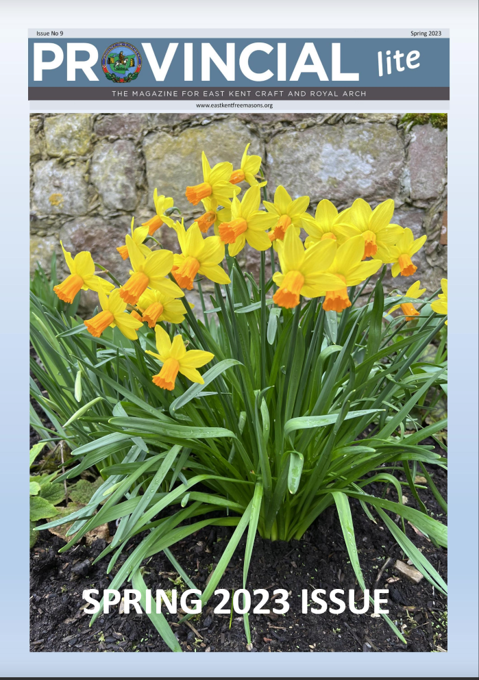 the front cover of this springs magazine, daffodils in front of a stone wall