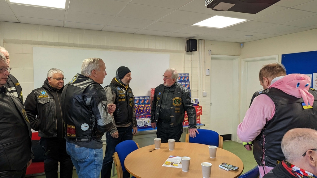 Into the warmth of the community centre, the widows sons gather for a hot drink
