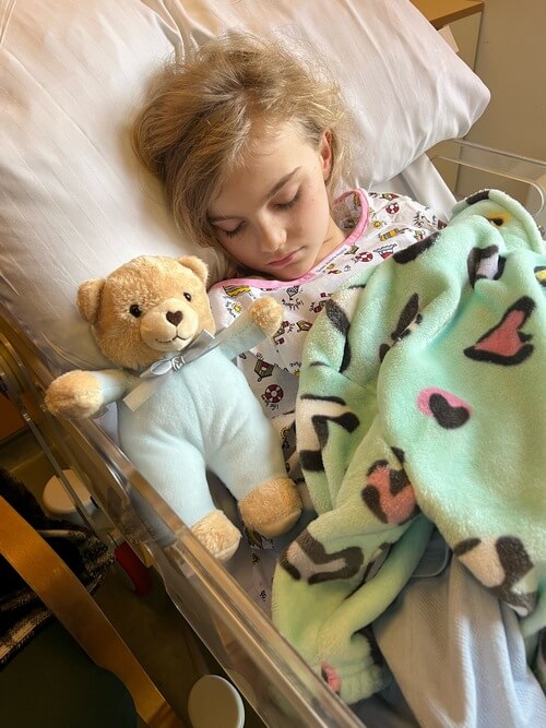 A picture of Ruby after her operation holding Mason a Teddy for Loving Care