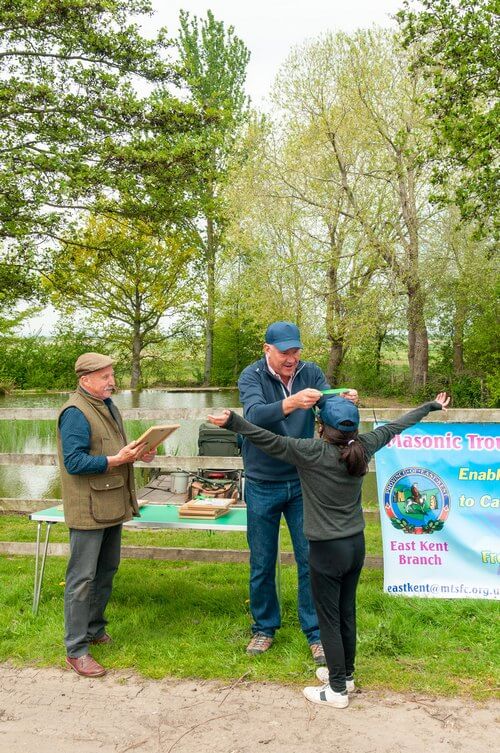 Mark Costelloe presents one of the students with a medal after fishing