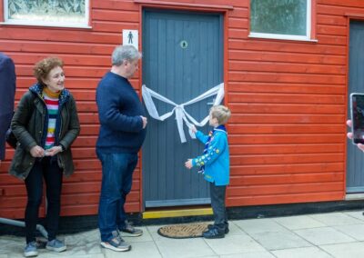 One of the young Scouts pulls the ribbon to the toilet block, during the opening ceremony.