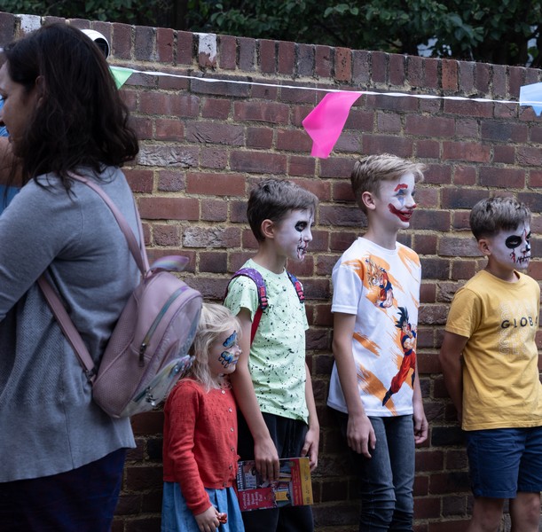 Children lining up after having their faces painted, looking splendid.