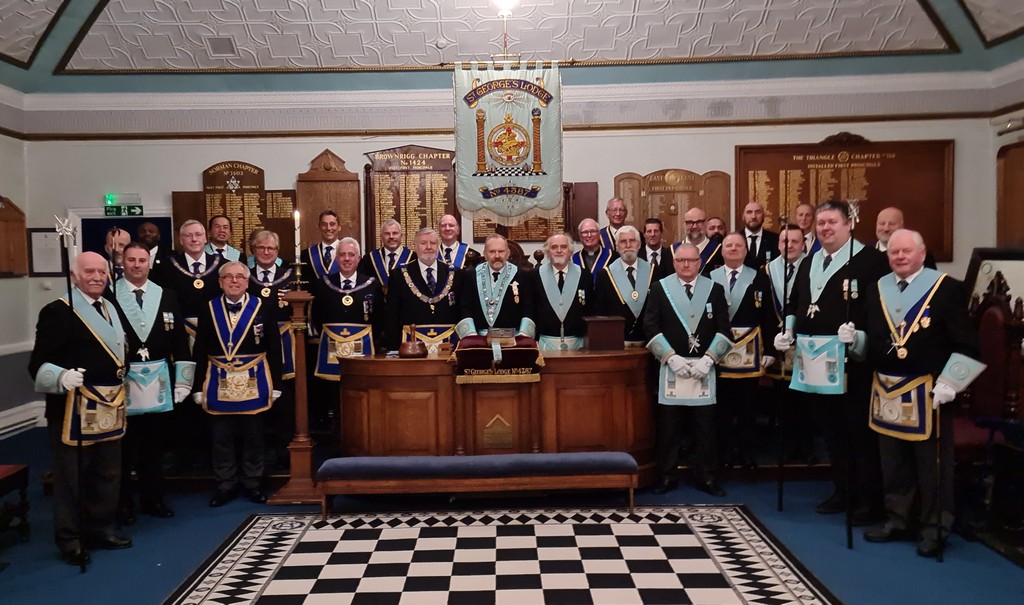 Group photo of the members and visitors to the lodge 100th meeting, all in the lodge room in full regalia.